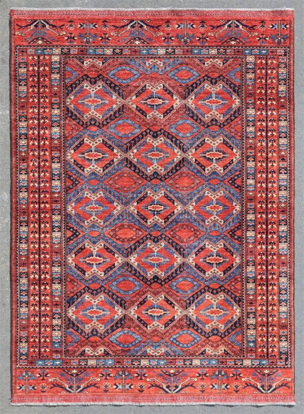 Knotted by hand in Afghanistan by Turkoman weavers using hand-carded, hand-spun, vegetable-dyed wool. A classic Beshir design woven in a centuries-old Turkoman tradition that flourished along the Amu Darya River of Central Asia. The rhythmic lattice of elongated diamond motifs and geometric medallions is set within a warm madder-red field, framed by traditional tribal borders woven with stylized flowering plants and protective symbols.